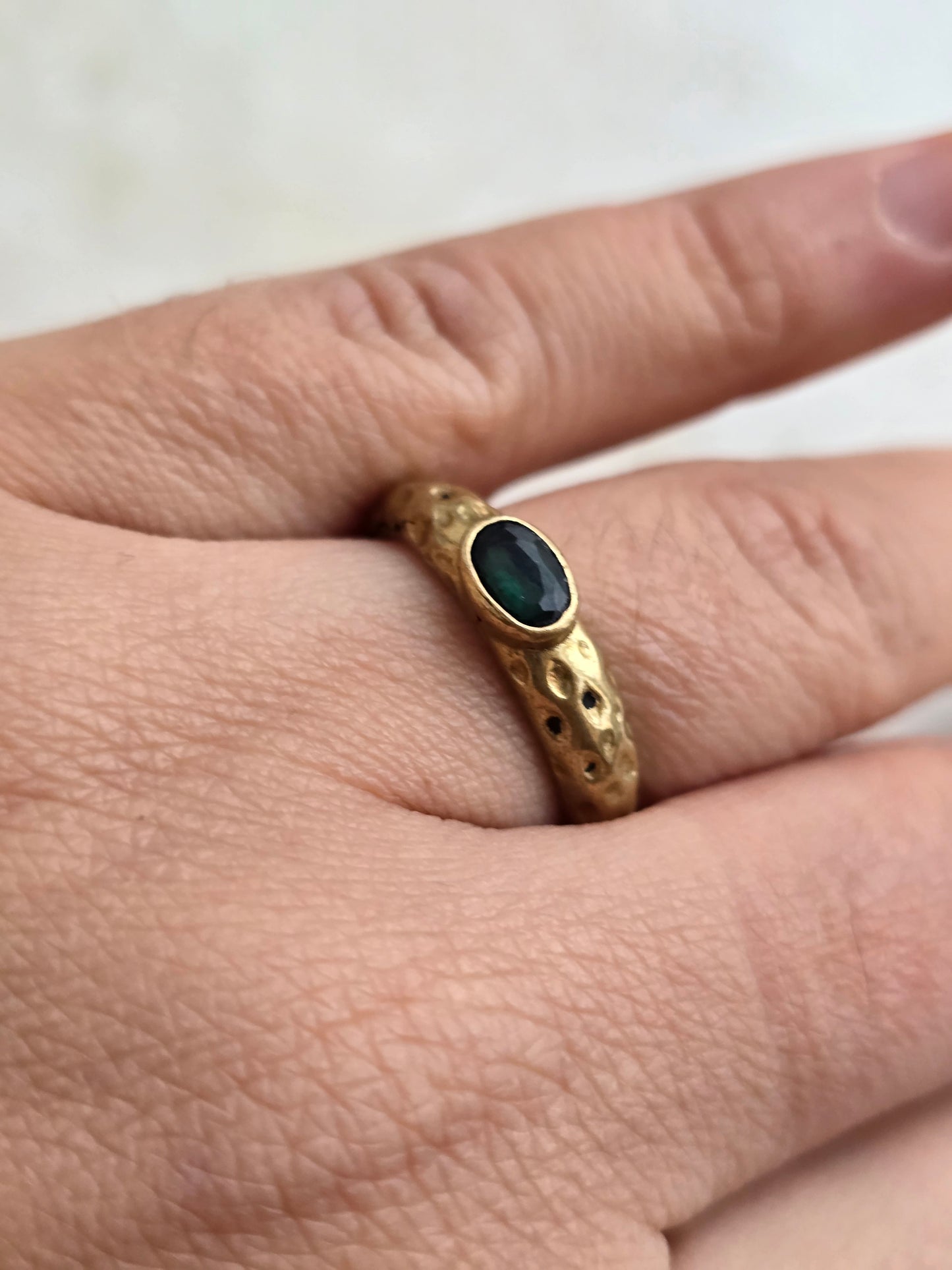 Žalvario spalvos žiedas su smaragdo spalvos stiklo kristalu