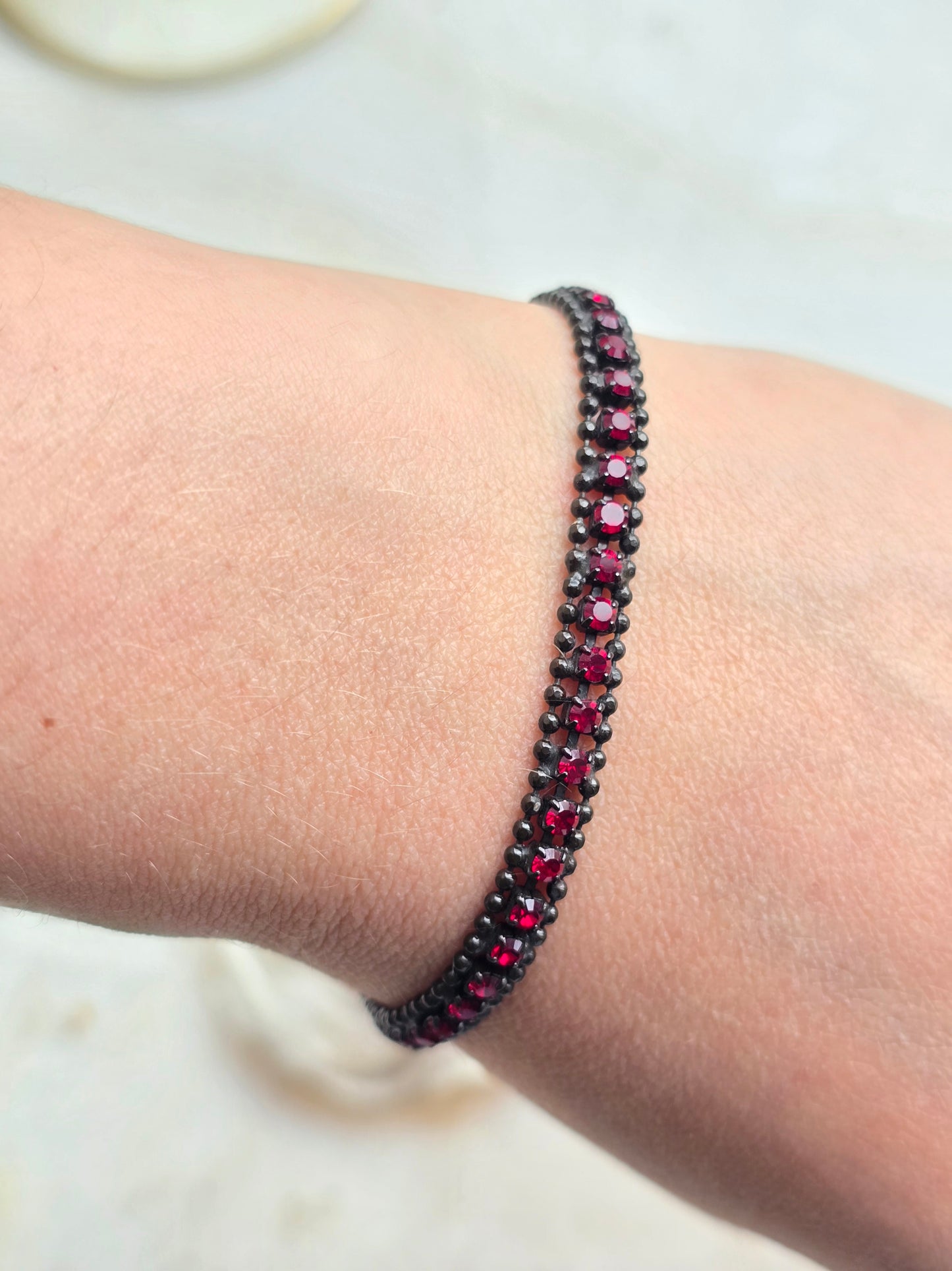 AGATHA PARIS juoda apyrankė su raudonais stiklo kristalais