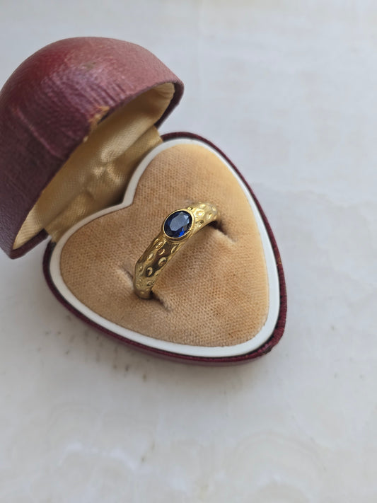 Žalvario spalvos žiedas su tamsiai mėlynu stiklo kristalu